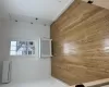 Empty room with light wood-type flooring, radiator heating unit, and a wall mounted AC