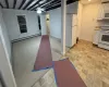 Kitchen with white cabinetry, ceiling fan, baseboard heating, light colored carpet, and white appliances