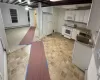 Kitchen featuring white appliances, white cabinetry, and a baseboard heating unit