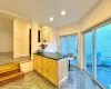 Kitchen featuring light brown cabinets, dark stone countertops, and kitchen peninsula