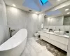 Full bathroom with lofted ceiling with skylight, toilet, tile walls, and shower with separate bathtub