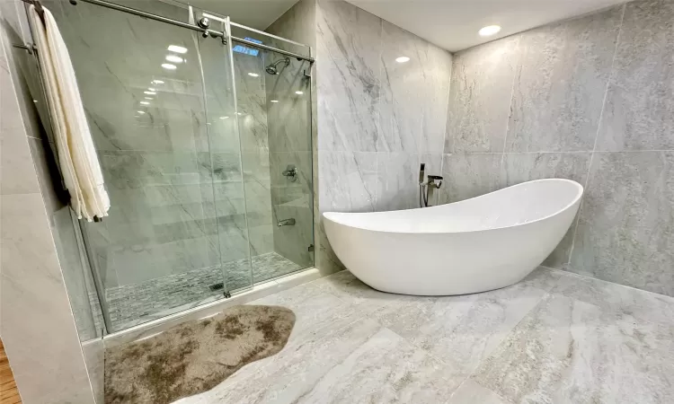 Bathroom with independent shower and bath and tile walls