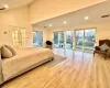 Bedroom featuring high vaulted ceiling, light wood-type flooring, access to outside, and french doors