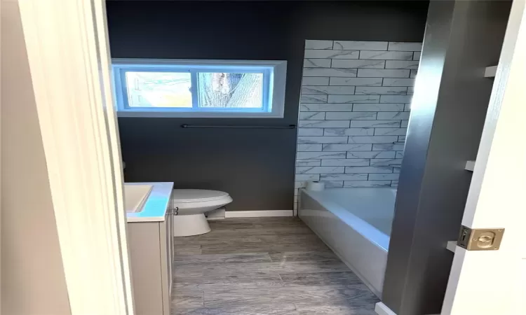 Full bathroom with vanity, toilet, and tiled shower / bath combo