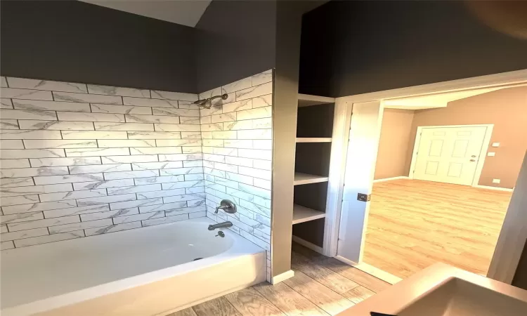 Bathroom with bathtub / shower combination and hardwood / wood-style flooring