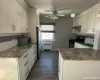 Kitchen with stone counters, hanging light fixtures, appliances with stainless steel finishes, tasteful backsplash, and radiator heating unit