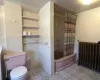 Bathroom featuring radiator heating unit, tile patterned flooring, tile walls, toilet, and shower / tub combo