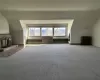 Bonus room featuring a brick fireplace, radiator heating unit, carpet, and vaulted ceiling