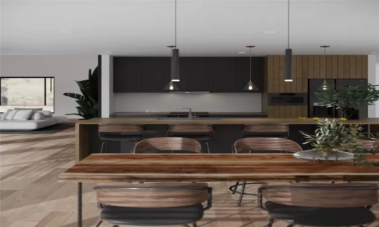 Kitchen featuring light wood-type flooring, a breakfast bar, sink, oven, and hanging light fixtures