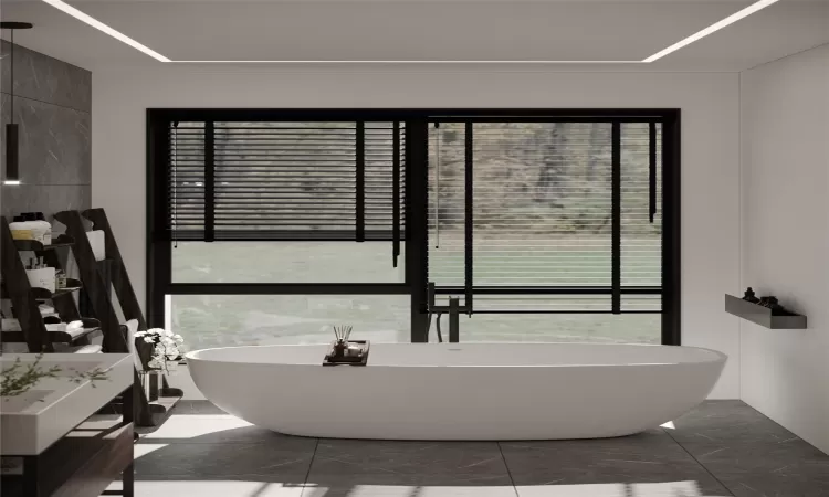 Bathroom featuring tile patterned flooring, a washtub, and a wealth of natural light