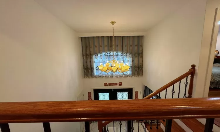 Stairway featuring a chandelier and a towering ceiling