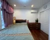 Bedroom with a wall unit AC, dark hardwood / wood-style flooring, and a closet