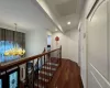 Corridor with dark hardwood / wood-style flooring and an inviting chandelier