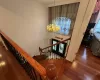 Stairway featuring hardwood / wood-style floors, plenty of natural light, and a notable chandelier