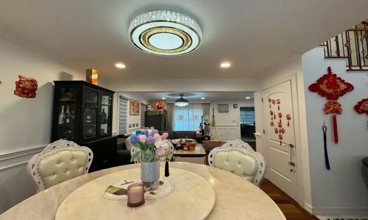 Dining area featuring crown molding and dark wood-type flooring