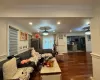 Living room featuring dark hardwood / wood-style flooring, ceiling fan, and ornamental molding