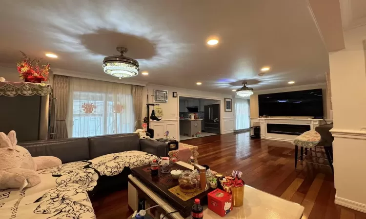 Living room with dark hardwood / wood-style floors and ornamental molding