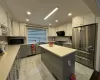 Kitchen featuring white cabinets, a center island, high end appliances, and sink