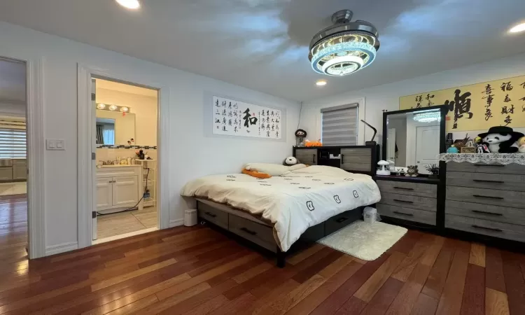 Bedroom featuring ensuite bathroom and dark hardwood / wood-style floors