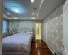 Bedroom featuring a raised ceiling and dark wood-type flooring