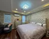 Bedroom featuring dark hardwood / wood-style floors, a wall unit AC, and a tray ceiling