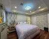 Bedroom featuring a raised ceiling and dark wood-type flooring