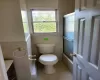 Full bathroom with vanity, tile patterned floors, toilet, enclosed tub / shower combo, and tile walls