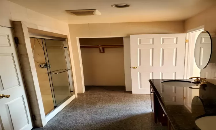 Bathroom featuring vanity and a shower with door