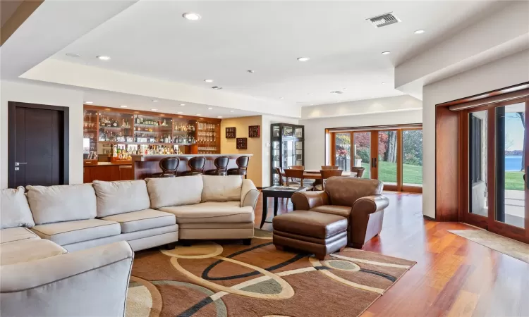 Living room featuring light hardwood / wood-style floors, french doors, and indoor bar