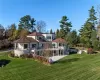 Rear view of property with a lawn, a balcony, and a patio