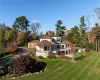 Rear view of property with a garage and a yard