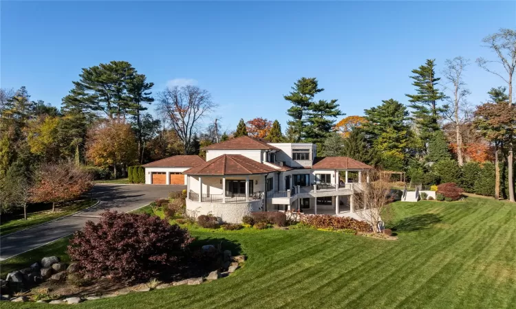 Rear view of property with a garage and a yard