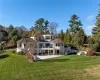 Rear view of house with a lawn, a balcony, and a patio