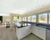 Kitchen with white cabinetry, sink, dishwasher, decorative light fixtures, and decorative backsplash