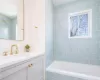 Bathroom with tiled shower / bath combo and vanity