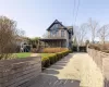 View of front of property with a porch and a playground