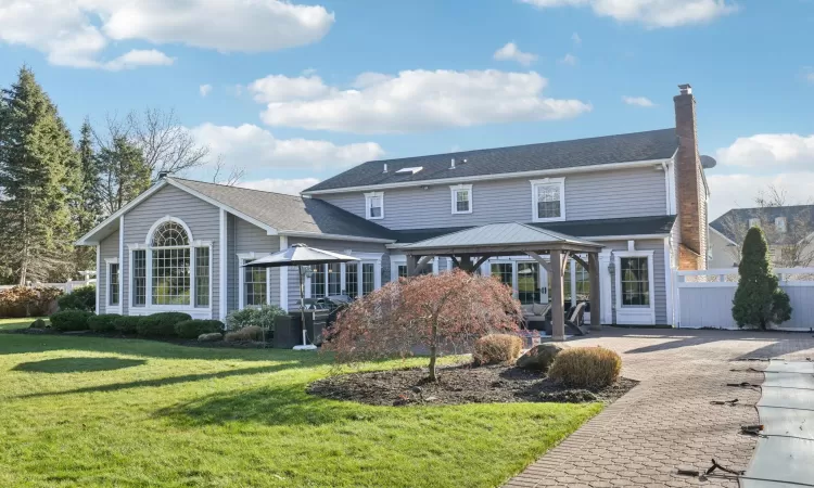 Back of property with a lawn and a patio