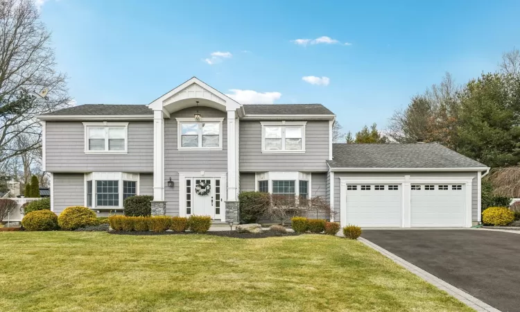 View of front of property featuring a garage and a front yard