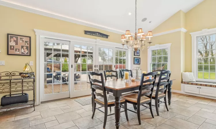 Kitchen featuring backsplash, white cabinetry, black appliances, and hanging light fixtures