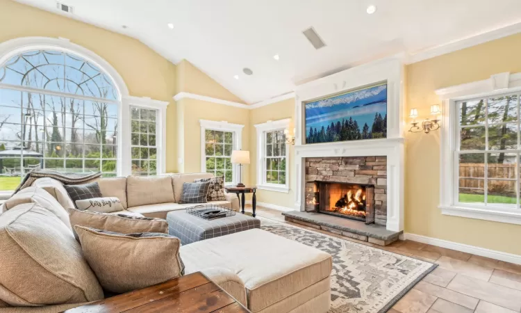 Living room with a chandelier, a healthy amount of sunlight, and vaulted ceiling