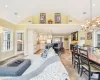 Living room with a stone fireplace, vaulted ceiling, and ornamental molding