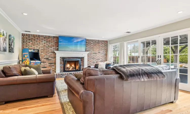 Living room with crown molding, a fireplace, and vaulted ceiling