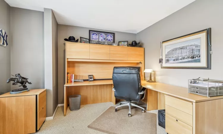 Office space featuring light wood-type flooring, a tray ceiling, and ornamental molding