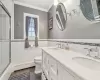 Bathroom with toilet, vanity, tile walls, and a baseboard heating unit