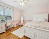 Bedroom featuring hardwood / wood-style flooring, ceiling fan, and ornamental molding