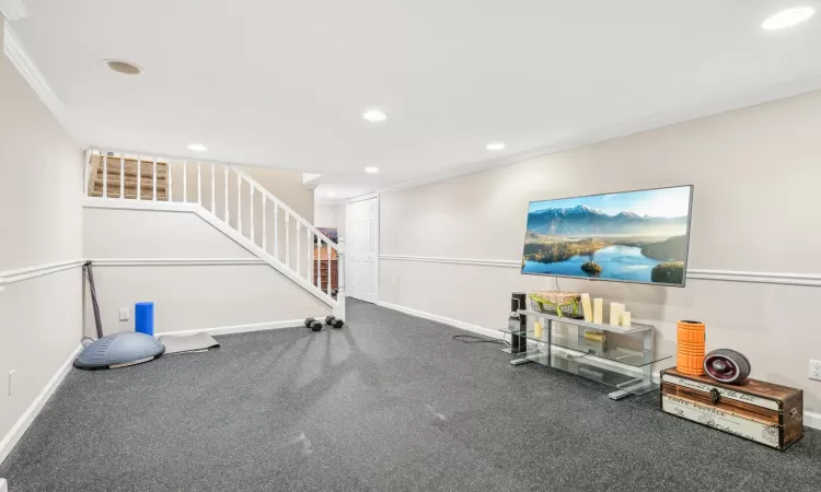 Bedroom featuring baseboard heating, ceiling fan, crown molding, and light wood-type flooring