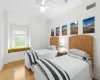 Bedroom featuring hardwood / wood-style floors, ceiling fan, crown molding, and a closet