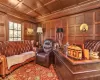 Living room with coffered ceiling, crown molding, wood walls, and wood ceiling