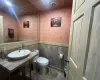 Bathroom with vanity, tile walls, and toilet