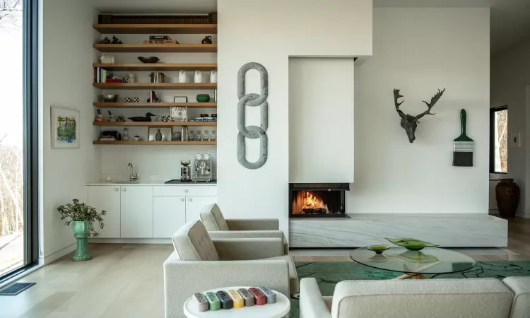 Dining room with a multi sided fireplace, sink, and light wood-type flooring